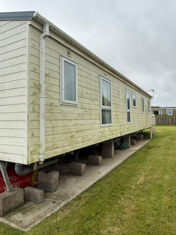 Static caravan cladding turned green with algae before cleaning